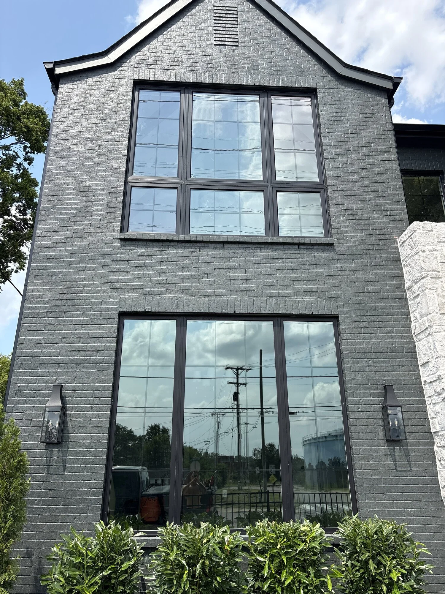 Two-story home with freshly painted charcoal brick and black-framed windows